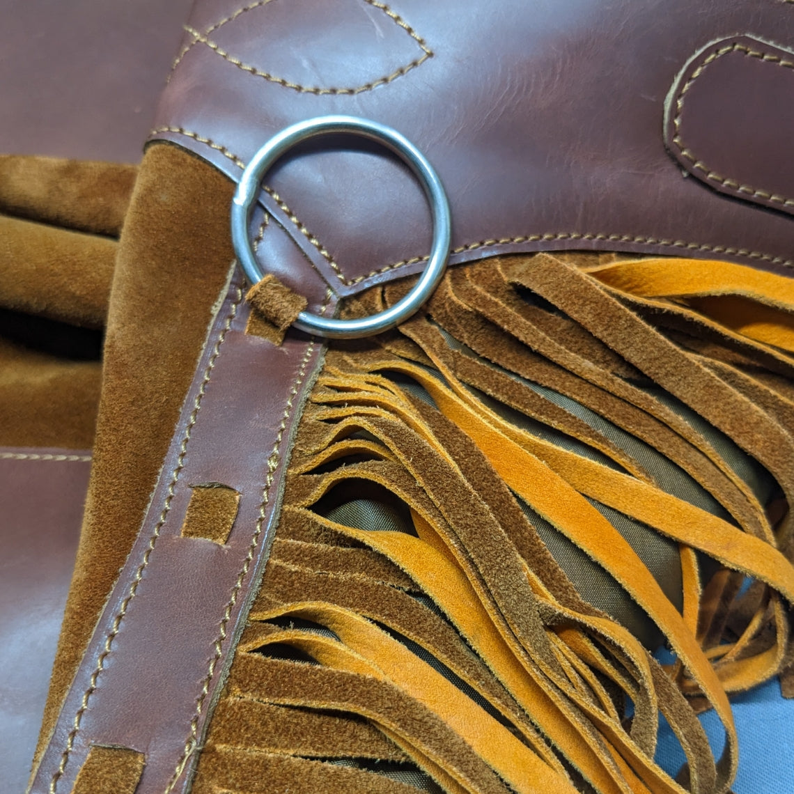close up suede leather chaps with metal ring fringe detail