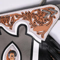 Close up of floral tooled yoke on gray rodeo chaps