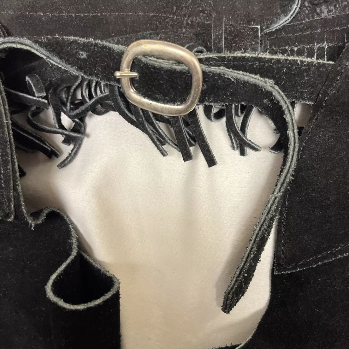 black suede chaps belt buckle close-up