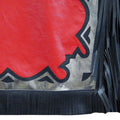 Close-up of black fringe and silver border on red chaps