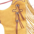 Close-up of cross design and conchos on tan rodeo chaps