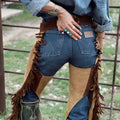 Back view of brown and tan suede western chaps with belt and fringe