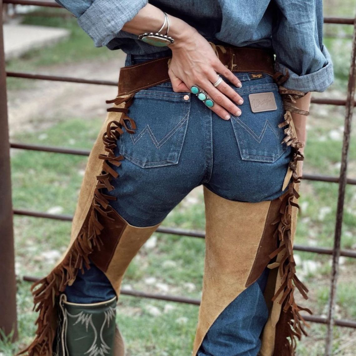 Back view of brown and tan suede western chaps with belt and fringe